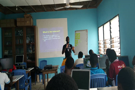 A community leader from Digital Grassroots in front of a classroom, training his community on digital literacy.