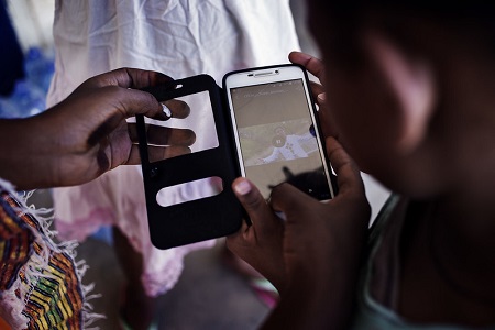 Image of a refugee using a mobile phone. From ODI/Gabriel Pecot (https://www.flickr.com/photos/overseas-development-institute/33059506181/)