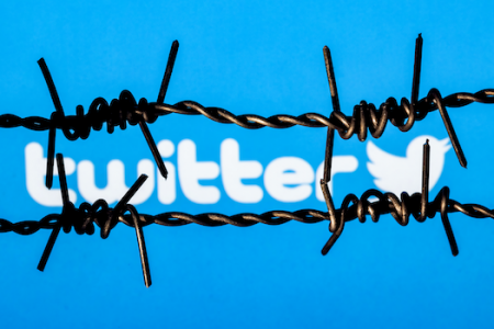 a graphic showing two strands of barbed wire in front of the Twitter name and logo